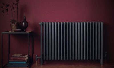 A black radiator against a maroon wall endorsing energy efficient home solutions
