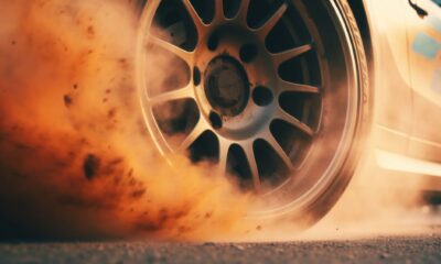 A car tire emitting smoke due to car exhaust backpressure