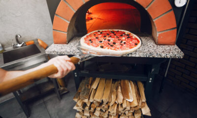 Chef putting pizza in pizza ovens