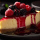 A delightful and refreshing dessert recipes idea by a cheesecake topped with fresh berries and a sprig of mint